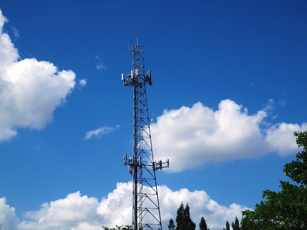 Communications Tower with blue sky and clouds in the background.