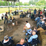 Visitors to Forge and Forum, a day-long workshop at Cloverdale Forge, watch a demonstration of blacksmithing.