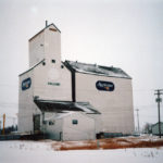 A wooden elevator at Holland was built in 1927 by a local co-operative working with Manitoba Pool Elevators. Its modest 50,000-bushel capacity was enlarged with a squat 75,000-bushel balloon annex in 1952 and a taller 85,000-bushel crib annex in 1958. The elevator was renovated thoroughly in 1982 and the balloon annex was removed around 1994. It survived the transfer to Agricore in 1998 but closed in early 2001 and was demolished in December 2003.