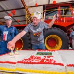 Dwayne Moorehead of Douglas, Man., operator and adoptee of the Versatile 1080 tractor known as Big Roy, lights the 40th birthday candle at the Thresherman's Reunion in Austin. Restored in 2016, the 30-foot, 600 horsepower tractor was built in 1977 and has been kept at the museum since 1979. Looking on (l-r) is Robert Beamish of Hamiota and Alex Campbell of Austin.