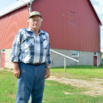 Cameron Dodds stands outside his 100-year-old barn south of Kenton, Man.