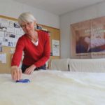 Janet Kroeker applies a wool batt to cotton encasement fabric as she works on product line for the family’s Rosa-area home-based business, Shepherd’s Dream.