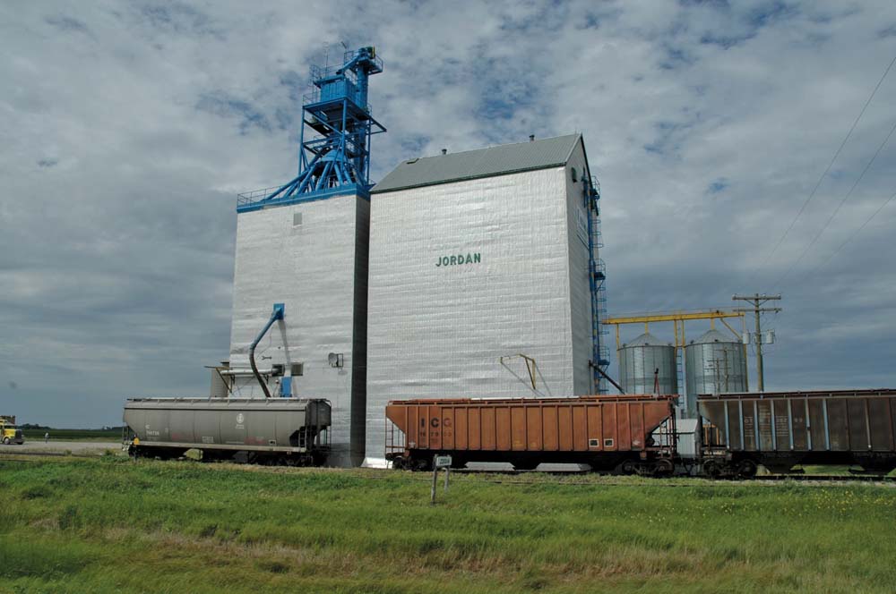 A 60,000-bushel wooden elevator was constructed between 1951 and 1952 at Jordan siding, in the RM of Roland, by Manitoba Pool, replacing a 40-year-old elevator at the site. A crib annex completed in 1960 increased its capacity to 133,500 bushels. Closed in July 1996, the elevator was sold to the newly founded Delmar Commodities of Winkler. The firm replaced the elevator’s spouts and established a soybean-crushing facility at the site. The adjacent railway line was closed in 2006.