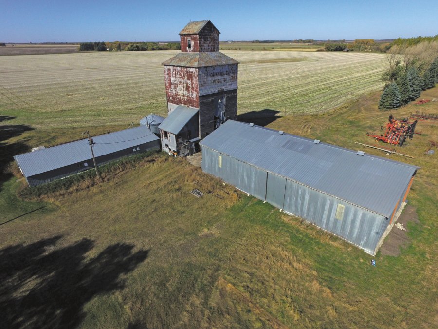 A 32,000-bushel wooden elevator on a farm in the RM of Portage la Prairie was built at Oakville in 1918 by Ogilvie Flour Mills. An annex was built beside it in 1951, increasing the total capacity to 62,000 bushels. Sold around 1960 to Manitoba Pool, it became known as “Pool B.” Closed in 1975, the elevator was sold and moved to its present site where it was used to store grain for an adjacent hog barn. Its rope-driven leg broke down in the early 1990s. Plans call for it to be deconstructed this fall so the lumber can be reused.