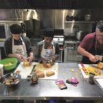 Owen Campbell (r) and members of the Wayfinders program prepare dishes for the Food Matters Manitoba AGM.