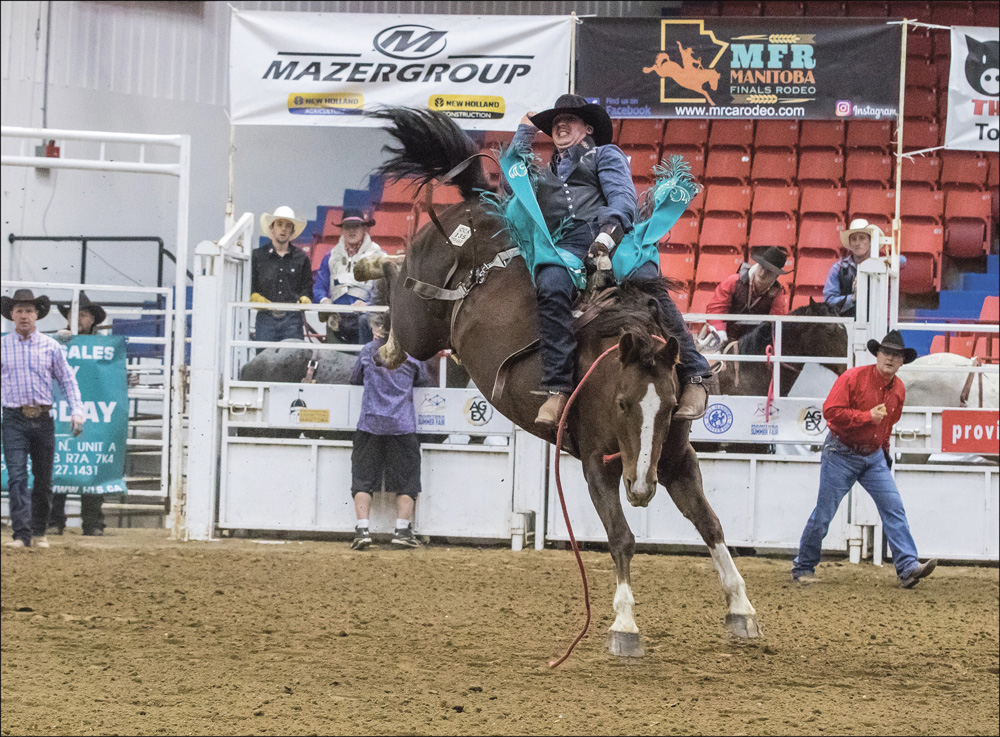 Holding on for all he’s worth, Calder Peterson of Glenworth, Sask. completes his eight seconds in the saddle bronc class. 