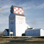 A 40,000-bushel wooden grain elevator at Elma, on the CNR Minaki Subdivision in the Rural Municipality of Whitemouth, was constructed in 1950 by the Canadian Consolidated Grain Company and sold to United Grain Growers in 1959. Described by UGG as being “from the beginning a low-volume grain point,” it was closed in March 1964 and moved to Whitemouth where it was converted into an annex for the elevator there that had also been bought from Canadian Consolidated. The facility was closed in July 1979 and later demolished.