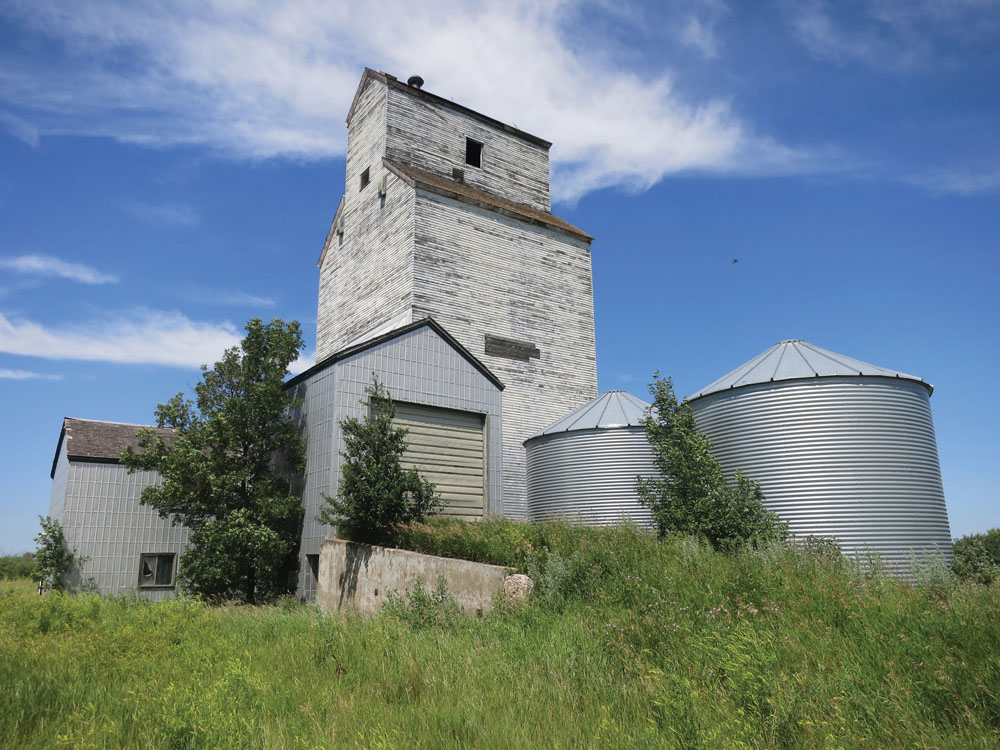 The first grain elevator in McConnell was built by J. H. McConnell and sold to the Canadian Elevator Company. Between 1926 and 1927, it was taken over by McConnell Cooperative Elevator Association. In 1928, the old elevator was demolished and a new one was constructed on the same site. A balloon annex was built beside it in 1940. Major renovations in 1968 included construction of a new driveway and office, and installation of a 40-ton scale. The final grain delivery occurred on December 16, 1978, the same day as the final train passed through town. The tracks were removed in May 1979 and the elevator was sold to a local farmer.