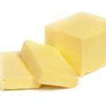 Stick of butter, cut, isolated on white.