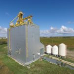 A 138,000-bushel wooden grain elevator on the CNR main line west of Elie  was built by Manitoba Pool in 1986 to replace a smaller facility in  town. It had a markedly different appearance from the elevators of old.  Its equipment for distributing grain into bins were fully exposed on top  and it was a modern composite that combined an elevator and annex into a  single crib. Closed between 2001 and 2002, it was sold to a consortium  of local farmers in 2004, who still use it for local storage.