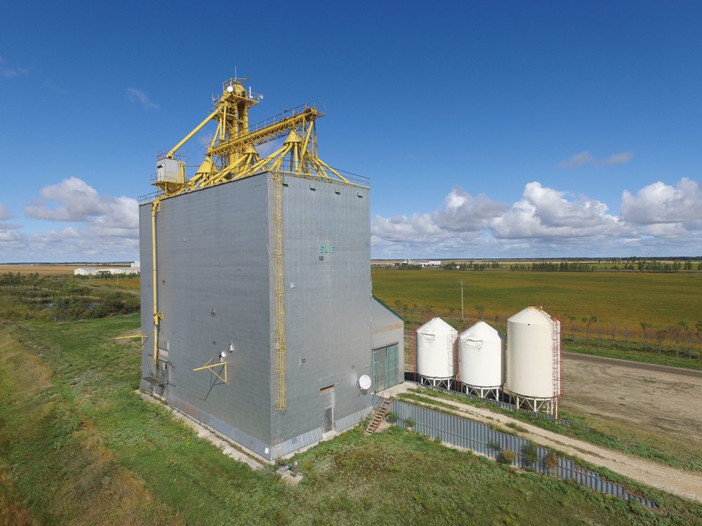 A 138,000-bushel wooden grain elevator on the CNR main line west of Elie  was built by Manitoba Pool in 1986 to replace a smaller facility in  town. It had a markedly different appearance from the elevators of old.  Its equipment for distributing grain into bins were fully exposed on top  and it was a modern composite that combined an elevator and annex into a  single crib. Closed between 2001 and 2002, it was sold to a consortium  of local farmers in 2004, who still use it for local storage.