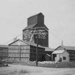 Annexes were built when more grain storage was needed than the elevator could provide. During the Second World War, numerous annexes were built across the Prairies to hold grain that could not be shipped to European markets. “Balloon annexes” were wooden frame structures, so named due to their tendency to balloon outward from the weight of grain inside. Here we see the Manitoba Pool elevator at Eden, in the RM of Rosedale, that had three balloon annexes when this photo was taken in the late 1940s. Built in 1928, the elevator closed in December 1977. Its railway line was abandoned in early 1981 and the tracks were removed. The elevator is no longer present at the site.