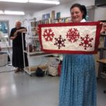 Andrea Maendel shows a snowflake table runner while Anna Maendel
looks on.