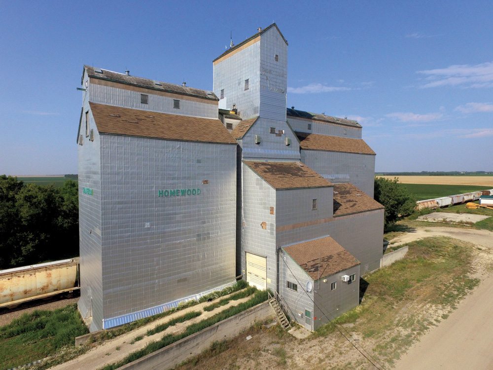 In late 1975, the CPR line between Carman and Kronsgart was abandoned. The Manitoba Pool elevator at Kronsgart closed in December 1976. It had been built for a local co-operative in 1952, along with a crib annex, to replace an elevator destroyed by fire in December 1949. A second crib annex had been added to it in 1955. In 1979, the Kronsgart elevator and annexes were moved 16 miles north to Homewood where they were renovated into a modern, high-throughput facility with a capacity of 186,000 bushels. Closed by Agricore in 2002, the elevator was sold into private ownership and put up for sale again in late 2014.
