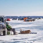 Wallace Stewart of Belmont waits for a strike while Trapper suns himself on Pelican Lake along with 885 other fishermen March 3.