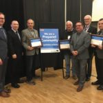 AMM president Chris Goerzen (left) and Manitoba Municipal Relations Minister Jeff Wharton (third from right) present one of four Emergency Preparedness awards to the Southern Emergency Response Committee. Outgoing emergency co-ordinator Chris Kalansky (back row from left), Morden Mayor Ken Wiebe, RM of Stanley Reeve Morris Olafson, Winkler Mayor Martin Harder and incoming emergency co-ordinator Darren Driedger accept the award.
