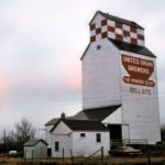 A 36,000-bushel elevator at Bellsite, 36 miles north of Swan River in the Rural Municipality of Mountain, was built in 1951 by Manitoba Pool Elevators and sold to United Grain Growers in March 1960. Seen in this photo from 1964, it was operated for a few years on a part-time basis, along with the elevator at nearby Novra, but increasing costs and low grain throughput led to its closure in November 1975. The elevator was used for private grain storage until September 16, 2007 when, nearly filled with grain, it was destroyed by fire.