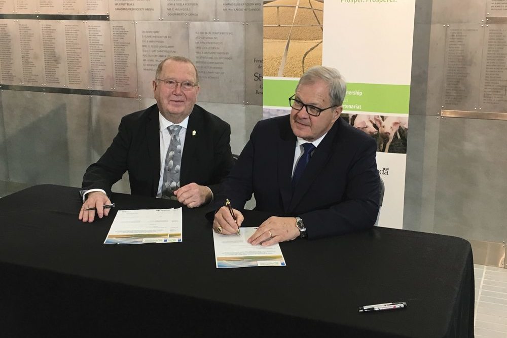 The federal and provincial agriculture ministers, Ralph Eichler (l) and Lawrence MacAuley, signed a new five-year bilateral agriculture agreement last week in Winnipeg.