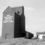 An elevator at Croll, on the CPR line about nine miles northwest of Boissevain, was operated by the Croll Cooperative Elevator Association as part of the Manitoba Pool network. An original 50,000-bushel elevator, built in 1930 to replace an elevator destroyed by fire, was joined by a 30,000-bushel elevator in 1940. Designated A and B respectively, they were merged into a single 80,000-bushel facility around 1952. Seen here in May 1972, the elevator was closed in December 1974, after the railway line was abandoned, and demolished in October 1976.