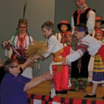 Colton Mackedenski (l), and Ruby Chegwin present a wheat sheaf and bread to Shari Leshchyshyn (l) and Nancy Drul.