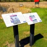 Signs in front of the Wetlands Discovery Trail near Cypress River deliver a conservation-focused message.