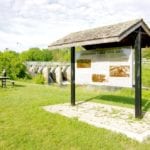 Signs near the Minnedosa Lake spillway talk about the development of the dam in 1912.