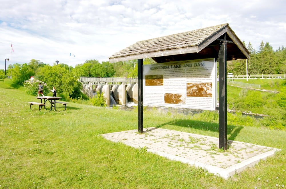 Signs near the Minnedosa Lake spillway talk about the development of the dam in 1912. 