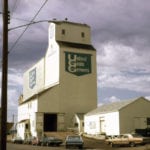 In March 1966, United Grain Growers opened a new 45,000-bushel elevator at Minnedosa. By the time this photo was taken in 1969, a large crib annex had been built beside it (in late 1967), increasing its capacity to 169,000 bushels. Closed in August 1999, the elevator was demolished in 2000. Source: University of Manitoba Archives & Special Collections