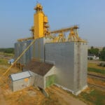 In 1980, an annex at Alexander was constructed by Manitoba Pool Elevators, next to an elevator dating from 1927. In early 1990, machinery from the elevator was salvaged then the elevator was demolished. A new elevator was built using the renovated office and drive shed from its predecessor. An official opening ceremony was held on September 5, 1990. Five days later, a former Paterson elevator that had stood immediately to the east was destroyed by fire. Three steel tanks were added in 1993 then the complex was closed by Agricore United in early 2002 and sold to a local grain processor.