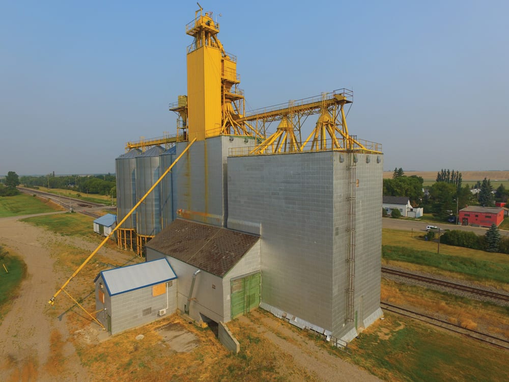 In 1980, an annex at Alexander was constructed by Manitoba Pool Elevators, next to an elevator dating from 1927. In early 1990, machinery from the elevator was salvaged then the elevator was demolished. A new elevator was built using the renovated office and drive shed from its predecessor. An official opening ceremony was held on September 5, 1990. Five days later, a former Paterson elevator that had stood immediately to the east was destroyed by fire. Three steel tanks were added in 1993 then the complex was closed by Agricore United in early 2002 and sold to a local grain processor.