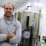 Alex Boersch has been inspired by nutrition farming techniques and is now trying them out on the family farm. Behind him is specialized equipment the farm now uses for solubilizing and mixing dry fertilizers or soil conditioners.