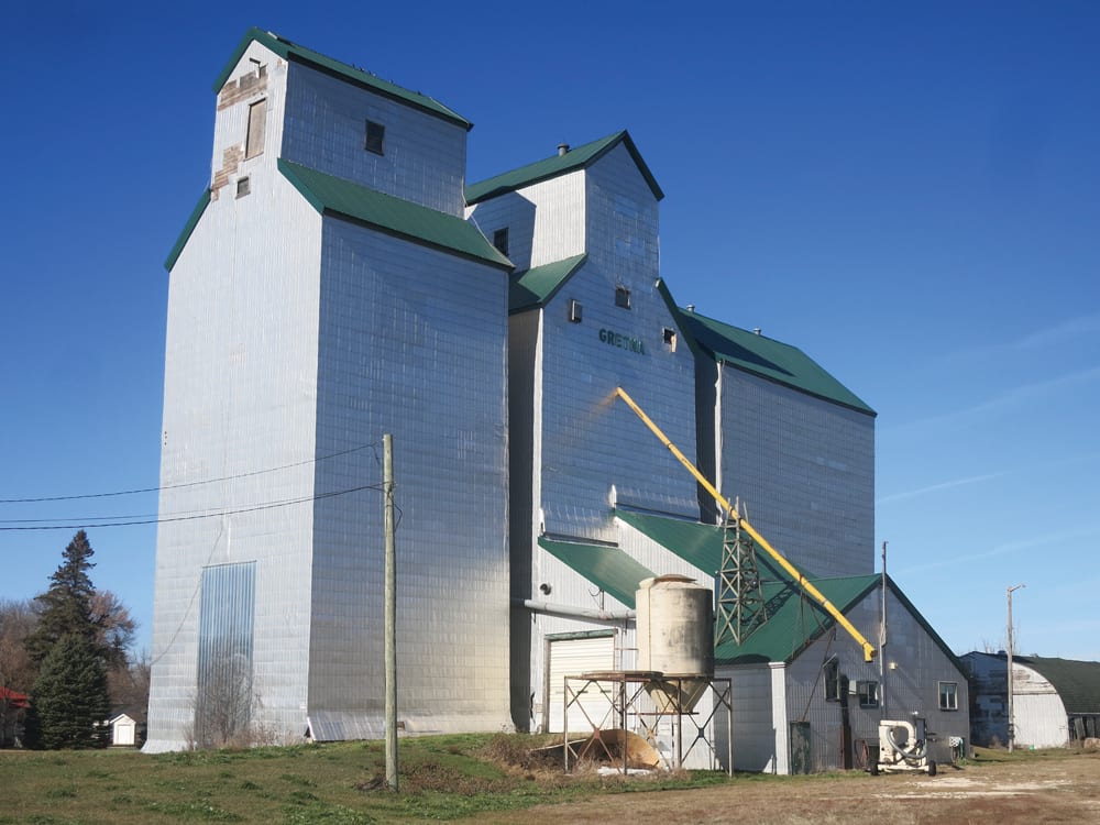 One of only two surviving elevators in the RM of Rhineland, the former Manitoba Pool elevator at Gretna was built in 1950. Its 50,000-bushel capacity was enlarged in 1967 with a new crib annex with room for another 70,000 bushels. Still more space was acquired through the Pool purchase of Federal Grain elevators in 1972, and the conversion of its elevator into a second annex. The railway line between Altona and Gretna was threatened with closure in the early 1980s but, after public outcry, it was saved and upgraded in 1985. It would prove a temporary reprieve. CPR abandoned the line on July 31, 1996, prompting the elevator to close the same day. It was later sold and used for private grain storage.