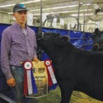 Justin Carvey of Alexander shows off his national championship banner after taking
Senior Champion Bull Calf this year at Ag Ex.