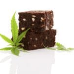 Delicious cannabis brownie with marijuana leaf isolated on white background.