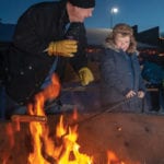 Don McRae of Wellwood and grandson Beckem Hofer enjoy a moment while roasting their hotdog after their sleigh ride.