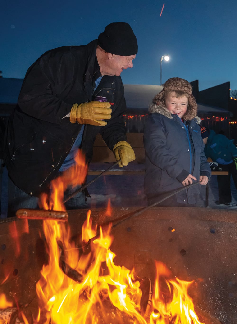Don McRae of Wellwood and grandson Beckem Hofer enjoy a moment while roasting their hotdog after their sleigh ride.