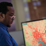 Geospatial analyst Chigo Ibeh reviews a land-cover map of Baltimore at the office of the Chesapeake Conservancy in Annapolis, Maryland.