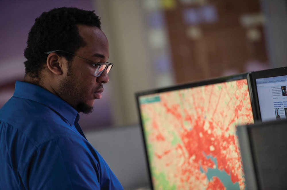 Geospatial analyst Chigo Ibeh reviews a land-cover map of Baltimore at the office of the Chesapeake Conservancy in Annapolis, Maryland. 
