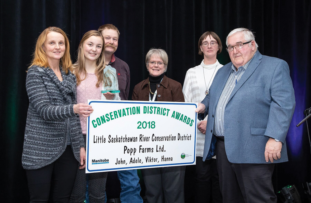 Adele Popp and her family were the recipients of a 2018 Conservation District award presented at the Dec. 11 banquet of the MCDA by Little Saskatchewan district manager Colleen Cuvelier (second from right) and board chair Ray Frey. Lorraine Stevenson presented on behalf of the Manitoba Co-operator which sponsors the awards.