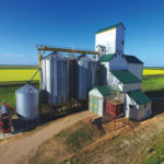 An elevator at Gregg, on the CNR line northeast of Carberry, was built in 1931 by the Scottish Co-operative Wholesale Society. A crib annex on its east side dates from 1955 and two steel tanks were added in 1991. Sold in 1973 to Manitoba Pool, its closure in October 2000 coincided with the merger of Agricore and UGG, although the Pool logo remained on its west side when this photo was taken in July 2017. It continues to be used for private grain storage.