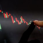 Close-up finger pointing on stock exchange chart