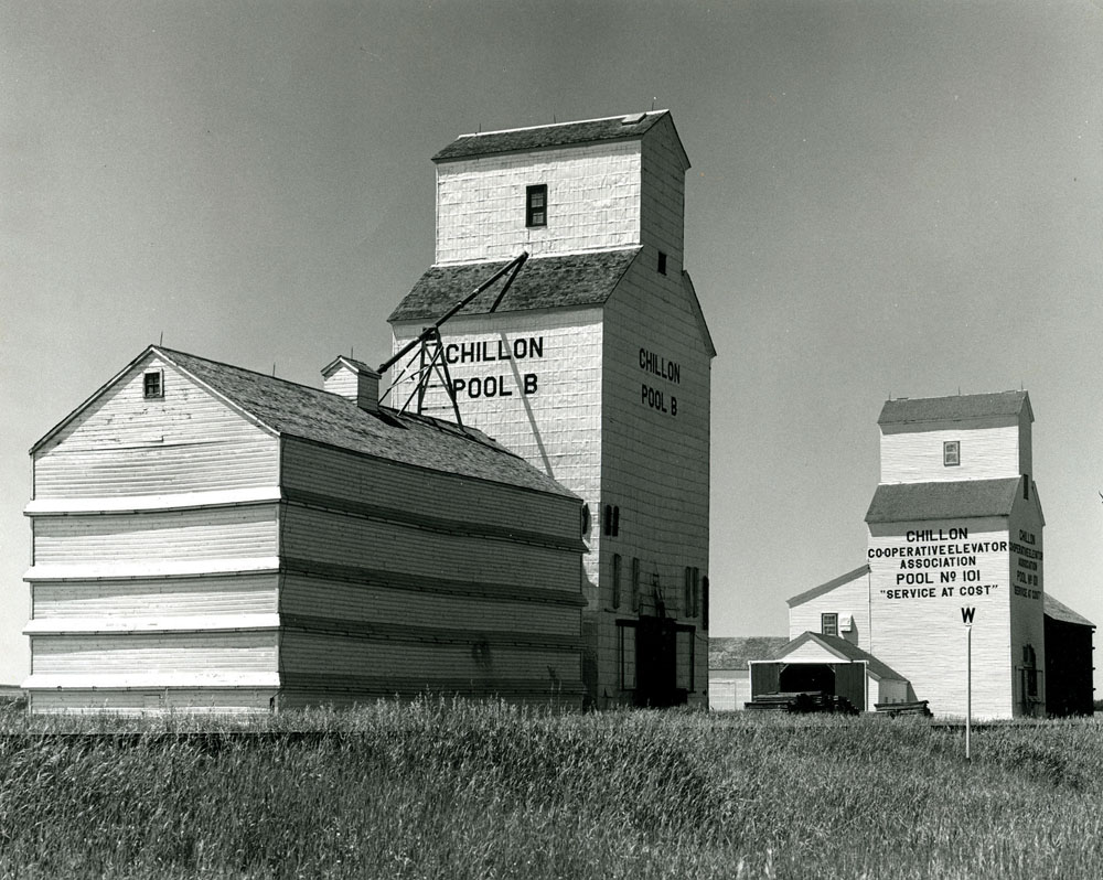 In 1929, the CPR announced that two elevators at the siding of Chillon, about four miles southeast of Binscarth, shipped more grain than 80 per cent of the other elevators in Manitoba. Seen here in the 1960s, Pool A at right was built between 1921 and 1922 by Paterson Grain. Sold to Manitoba Pool in 1928, its capacity was expanded in 1952 with a large balloon annex. The Pool B elevator at left was built in 1921 by United Grain Growers, expanded in 1952, and sold in 1960. The elevators were closed in mid-1971 and dismantled in 1972.