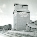A small stone monument in the Municipality of Riverdale is all that marks the location of Pendennis. Established in 1903 and named for a character in the 19th century novel The History of Pendennis, this siding on the CPR Lenore Subdivision had a post office, general store, and Manitoba Pool elevator, seen in this photo from August 1948. The last vestige was gone by March 1964 when the elevator was destroyed by fire.