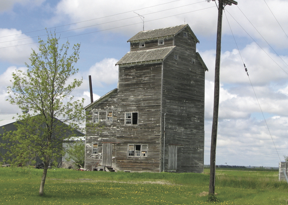 An elevator in the RM of Stanley was built in 1943 as a seed-cleaning plant for George G. Elias (1914-2012), on the former site of the Eichenfeld German School. A crew of 16 men built the state-of-the-art facility crib structure, which could process up to 1,000 bushels of grain each day, using 2x6 timbers at a cost of about $8,000. In 1946, Elias’s barley won first prize at the Royal Winter Fair in Brandon and, later that year, captured first prize in a national contest sponsored by the newly formed Barley Improvement Institute of Canada. It won the national award again in 1950 and Elias was proclaimed the “Barley King” of Manitoba. An active member of the Canadian Seed Growers Association for over 65 years, he continued to sell certified seed throughout Canada until retirement in 2000. The elevator was moved to the Pembina Threshermen’s Museum in February 2015 where it houses grain- milling demonstrations and a display of Elias family history.