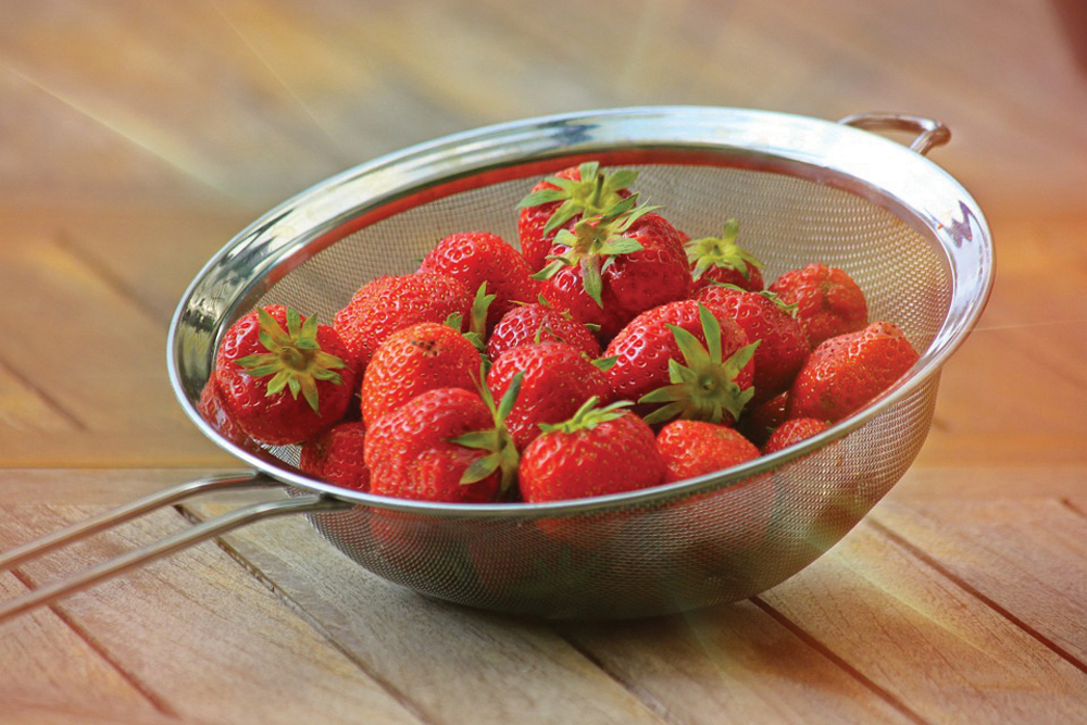 When buying strawberries, look for fruits that are bright red with green caps and are free from moisture or bruising.