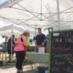 Andreas Zinn interacts with a customer at the St. Norbert Farmers’ Market.