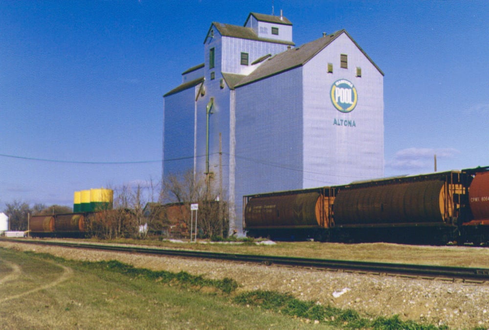 Altona Pool: This elevator at Altona was built in 1951 by Lake of the Woods Milling Company. Purchased by Manitoba Pool in 1959, it was the Pool B elevator until early 1965 when Pool’s A elevator was moved to Plum Coulee. Crib annexes were built on each side of it in 1967 and 1969, and the elevator was fully renovated in 1970. Closed by Agricore in 2001, the elevator was demolished.