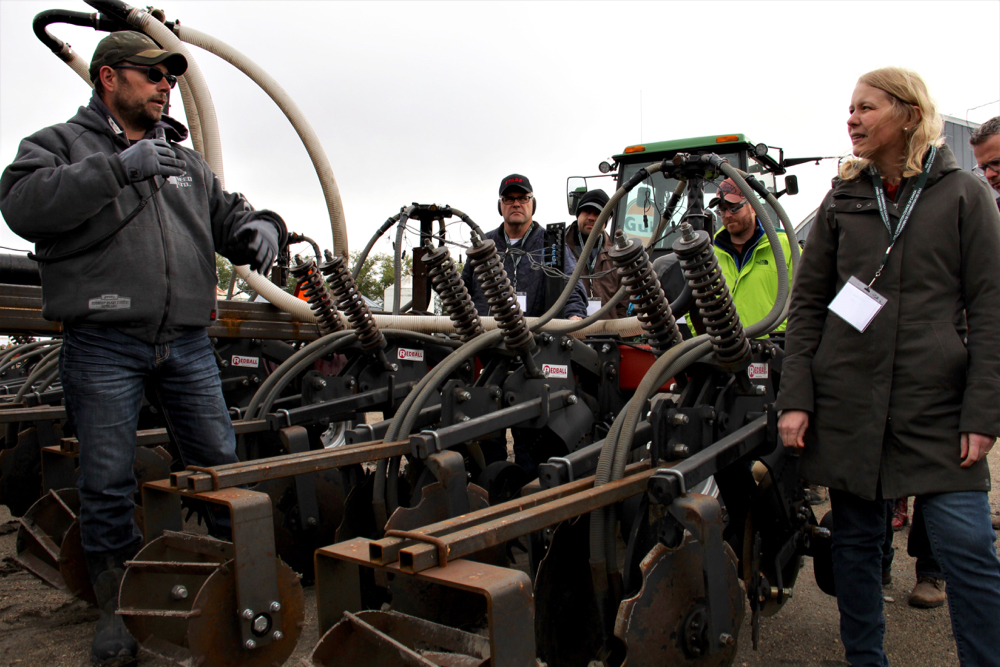 Ryan Pritchard and Yvonne Lawley point out the features of his strip tiller, which Pritchard modified himself.