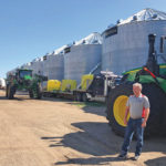 Farmer Mike Appert stands in front of some of his storage bins and machinery on his 48,000-acre farm in Hazelton, North Dakota on July22.