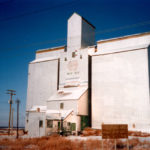 In 1962, an elevator was built by Federal Grain at Mile 10.6 along Wilkes Avenue on the outskirts of Winnipeg (known in the 1930s as the St. Charles Siding). Initially accompanied by a single crib annex, its capacity was expanded with a second annex in 1965, raising its total to 155,000 bushels. Sold to Manitoba Pool in 1972, a local management committee was formed in February 1973. Major renovations were undertaken in early 1988. The elevator closed around 2000, shortly before this photo was taken, and was demolished in early 2003.